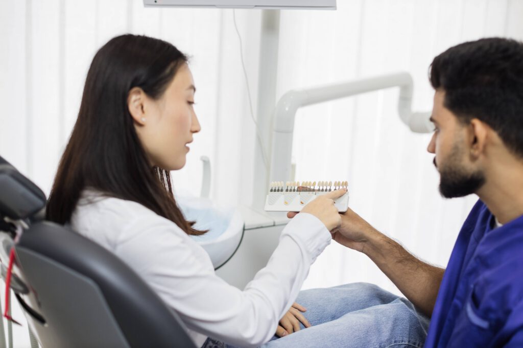 Dentist explaining dental procedure to patient with shade guide